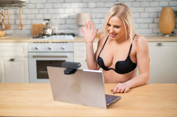 A girl in lingerie flirts on a webcam on a laptop. A woman works in the online sex industry - Foto, Imagem