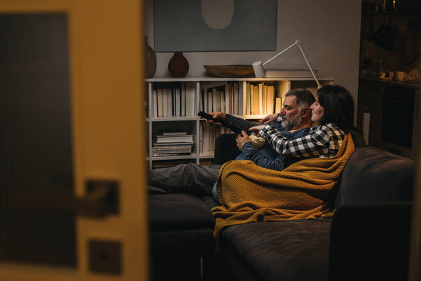 middle age couple relaxing at home watching tv - Фото, изображение