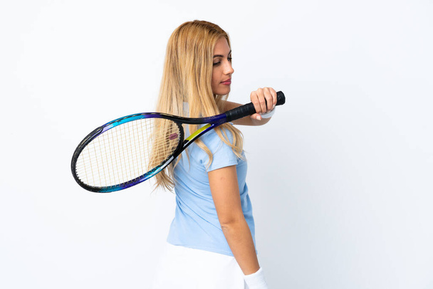 Jeune femme blonde uruguayenne sur fond blanc isolé jouant au tennis - Photo, image