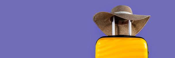 Bright and stylish cabin size suitcase with straw hat - Photo, Image