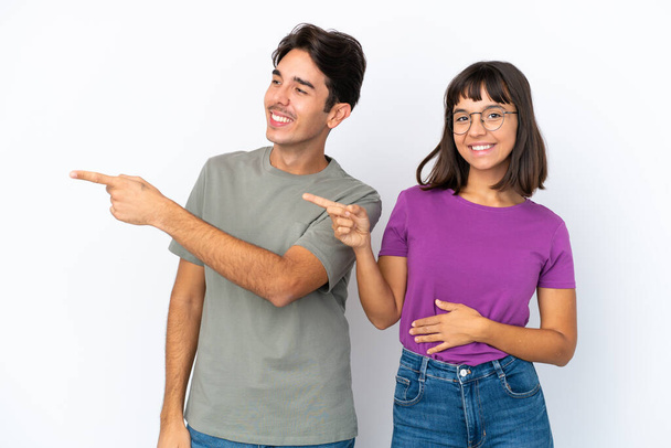 Nuori pari eristetty eristetty valkoisella taustalla osoittaa sormella sivulle sivusuunnassa - Valokuva, kuva