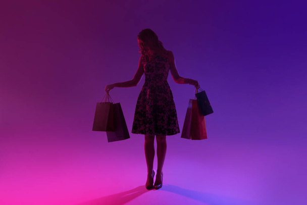 Elegant woman with bags and packages after shopping. - Foto, afbeelding