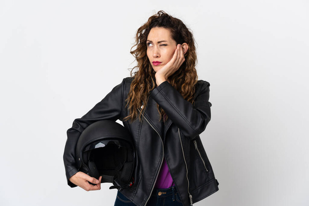 Young caucasian woman holding a motorcycle helmet frustrated and covering ears - Фото, зображення