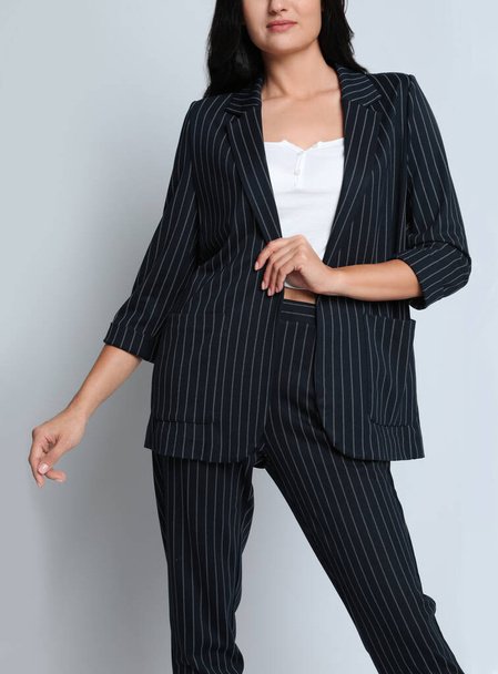 Woman in formal suit on light background, closeup. Business attire - Zdjęcie, obraz