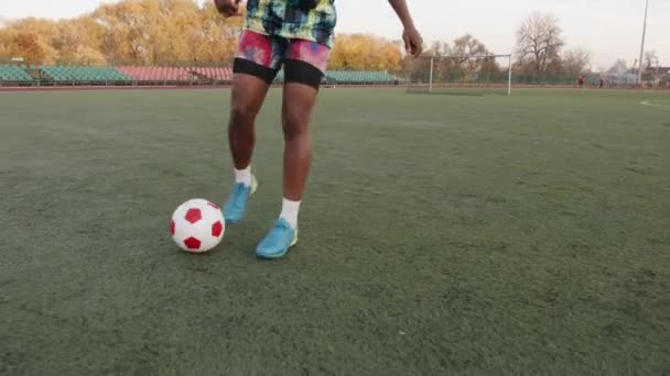 Mladá africká americká žena v tričku bez rukávů a šortkách hrající fotbal a cvičící míčové finty v pohybu - Záběry, video