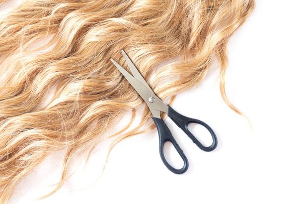 Beautiful blond hair and open hairdresser scissors top view. Cutting hair concept - Fotó, kép