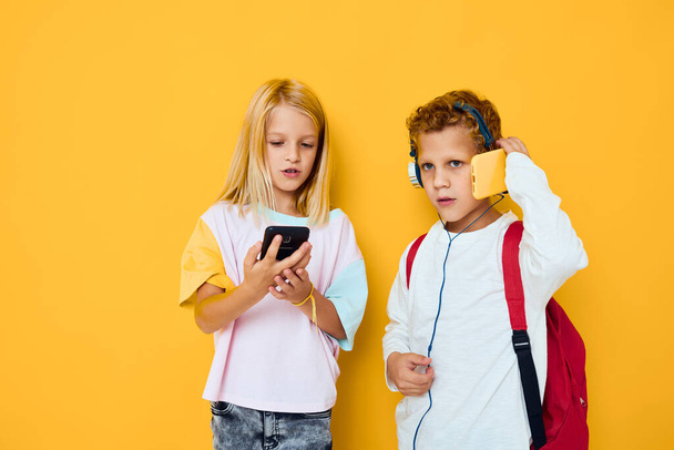 teenage boy and girl with school backpacks phone entertainment communication Studio education concept - Foto, afbeelding