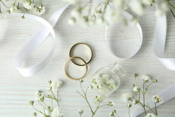 Concept of wedding accessories with wedding rings on white wooden background - Photo, Image