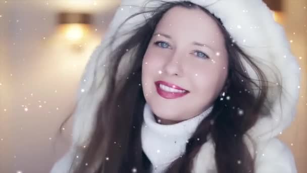 Moda de invierno y look navideño. Hermosa mujer sonriente con suéter blanco y abrigo de piel con capucha esponjosa, nevando nieve y copos de nieve - Metraje, vídeo