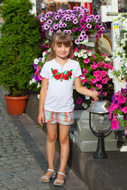 χαρούμενο κορίτσι στην ουκρανική κέντημα στο floral φόντο - Φωτογραφία, εικόνα