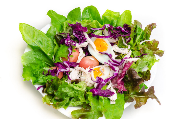 Verse salade met gekookt ei in een witte plaat - Foto, afbeelding