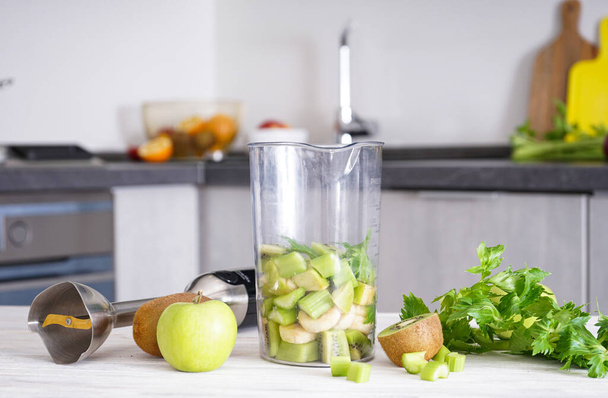 Ручной блендер для смешивания органических свежих фруктов для приготовления витаминного диетического смузи, здоровой пищи. - Фото, изображение
