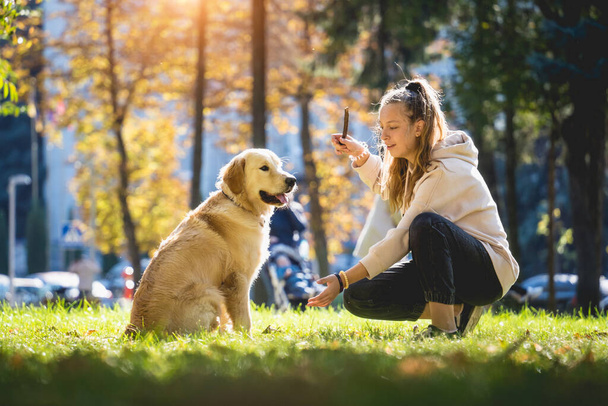 A tulaj játssza a golden retriever kutyát a parkban.. - Fotó, kép