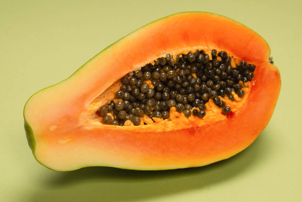 Papaya-Frucht auf grünem Hintergrund. Tropische Früchte. Halbe Papaya.  - Foto, Bild
