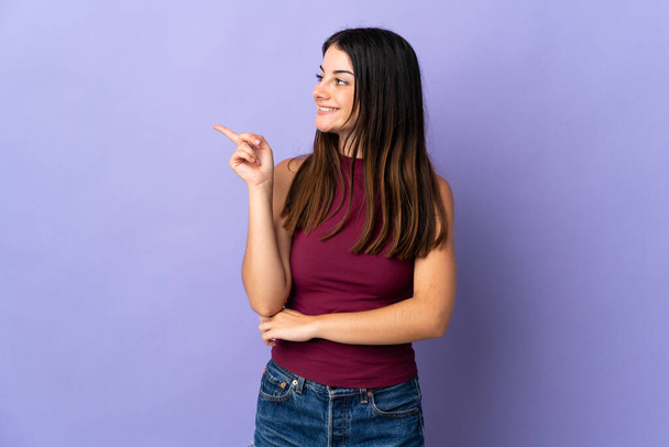 Young caucasian woman isolated on purple background pointing up a great idea - Фото, изображение