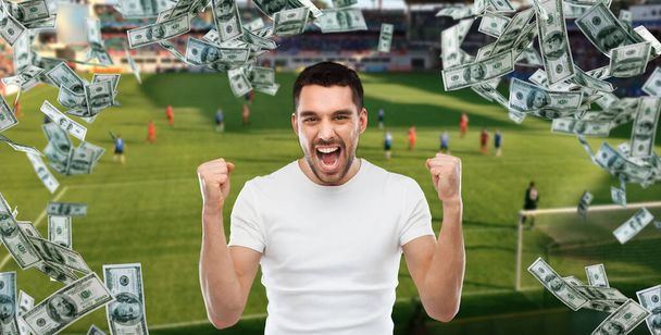 happy man with over money rain on football field - Foto, Imagem