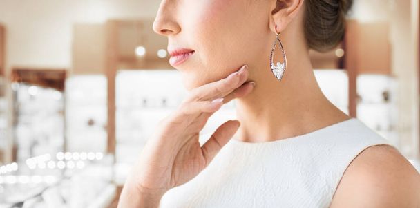 woman wearing pearl earring at jewelry store - Zdjęcie, obraz