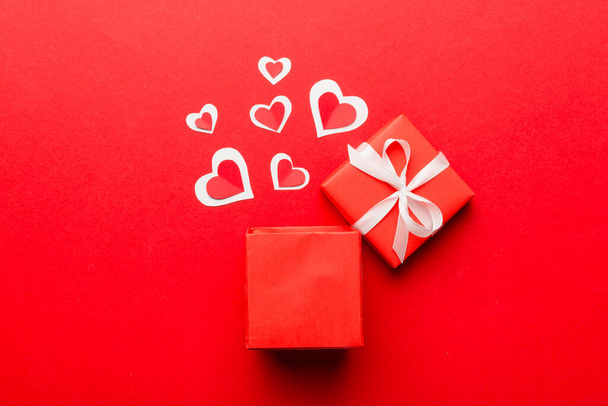 Hyvää Ystävänpäivä avasi sydämen muotoinen lahjapaketti, jossa on pienet sydämet, värillisellä taustalla, Ystävänpäivä kortti - ylhäältä näkymä käsite. - Valokuva, kuva