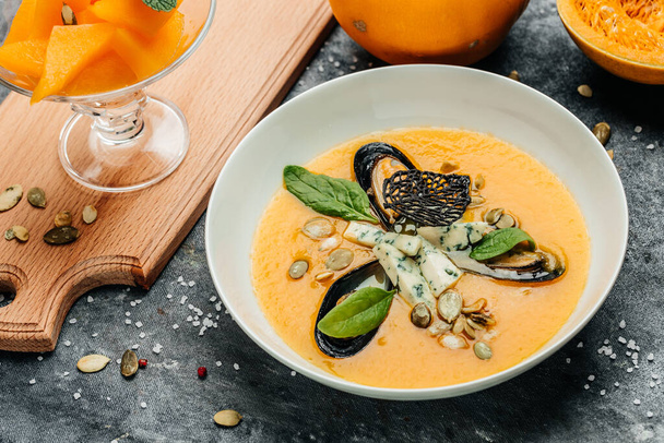 pumpkin soup with mussels in a bowl. Food recipe background. Close up. - Photo, image