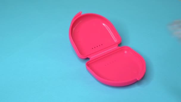Arzt setzt einen Zahnhalteapparat oder eine Zahnschiene aus einem rosafarbenen Boxset - Filmmaterial, Video