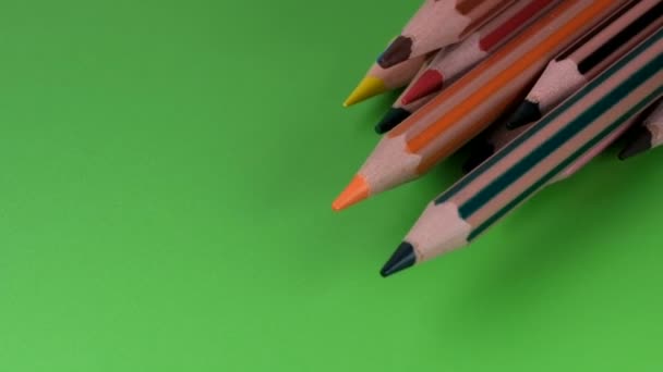 Kolorowe ołówki powoli zbierają się w jednym rzędzie z naostrzonymi końcami w dół, zbliżenie, zwolnione tempo, klip wideo - Materiał filmowy, wideo