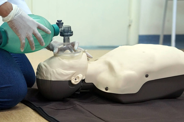 自動体外式除細動器を使用した基本的な生活支援中のシミュレーションダミーの学生による呼吸袋(Ambu)を使用します。シミュレーショントレーニングシナリオ - 写真・画像