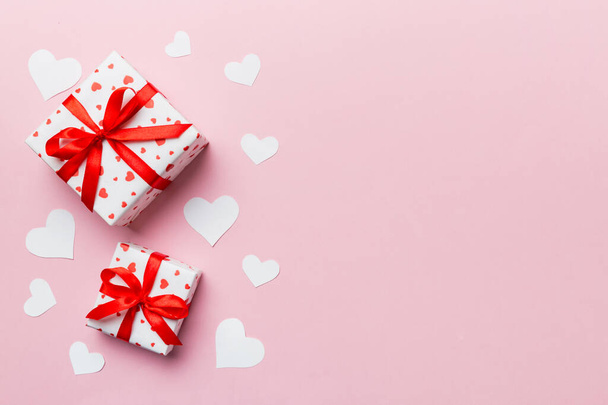 バレンタインデーの組成:弓と心を持つ赤いギフトボックス。クリスマスプレゼント。上からの眺め。テキスト用のスペース。ホリデーグリーティングカード. - 写真・画像