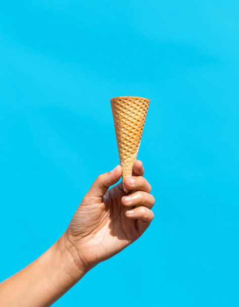 close up of hand holding empty ice cream cone - Foto, immagini