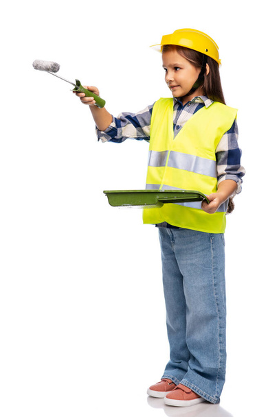 girl in helmet and safety vest with paint roller - Photo, image