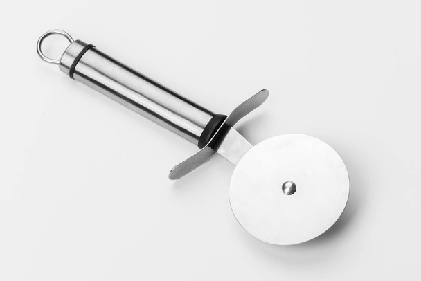 Hermoso cuchillo de acero para pizza sobre un fondo blanco. Cubertería aislada sobre fondo blanco - Foto, Imagen