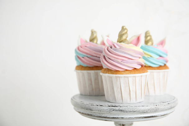 Leuke zoete eenhoorn cupcakes op dessert staan tegen een witte achtergrond. Ruimte voor tekst - Foto, afbeelding