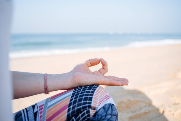 El meditasyon pozunda katlanır. Deniz kıyısında meditasyon ve yoga. Huzur, huzur ve uyum arayışı. Sahilde rahatla. Yüksek kalite fotoğraf - Fotoğraf, Görsel