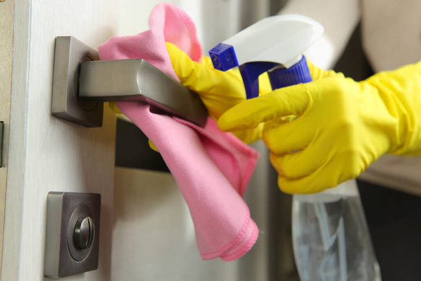Kadın kapı kolunu yıkar ve dezenfekte eder. Yayılan virüslerin önlenmesi. - Fotoğraf, Görsel