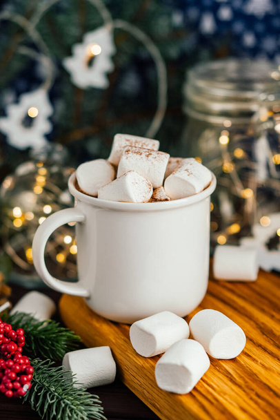 Bebida de Navidad chocolate caliente con malvaviscos en la decoración iluminada festiva. Enfoque selectivo - Foto, imagen