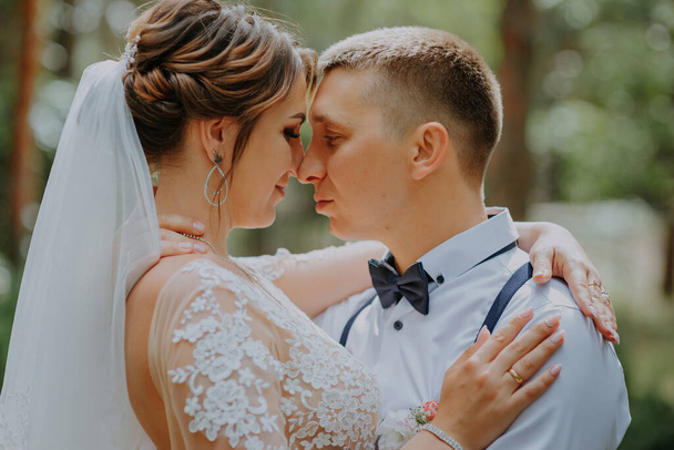 Sensual portrait of a young couple. Wedding photo outdoor. Wedding shot of bride and groom in park. Just married couple embraced. - Photo, image