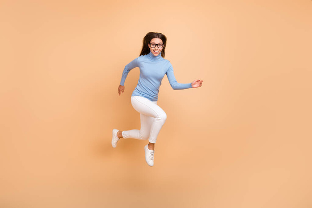 Full body profile photo of impressed millennial lady run wear eyewear pullover pants footwear isolated on beige background - Φωτογραφία, εικόνα