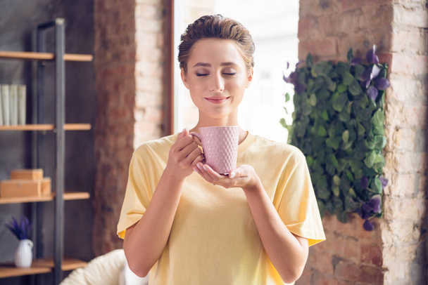 Photo of calm peaceful charming young woman smell coffee drink cup morning indoors inside house home - Foto, Bild