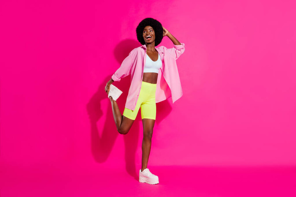 Photo of charming funny dark skin woman dressed crop top smiling dancing isolated pink color background - Foto, imagen