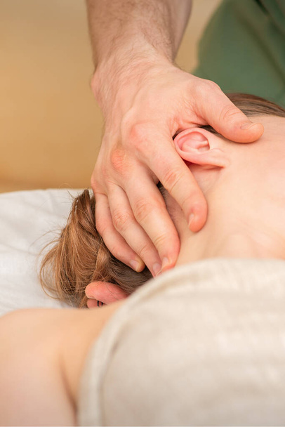 Osteópata haciendo masaje en la cabeza femenina en el centro clínico de rehabilitación - Foto, Imagen