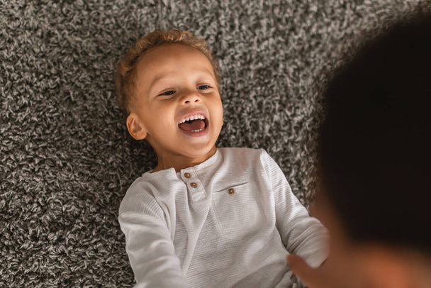 Matka lechtání radostný afroameričan malý chlapec doma - Fotografie, Obrázek