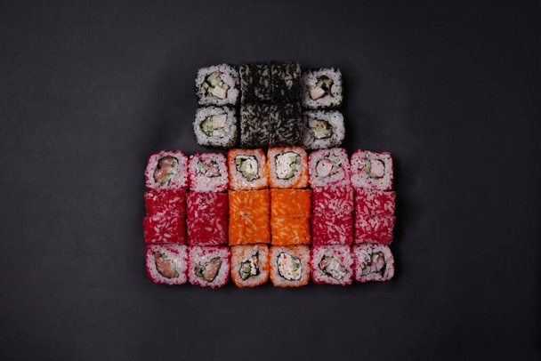 una porción de diferentes rollos en la mesa, comida japonesa, sushi en mármol, vista superior, palillos chinos - Foto, Imagen