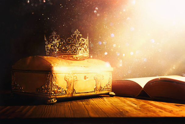 low key image of beautiful queen or king crown and old book. vintage filtered. fantasy medieval period - 写真・画像