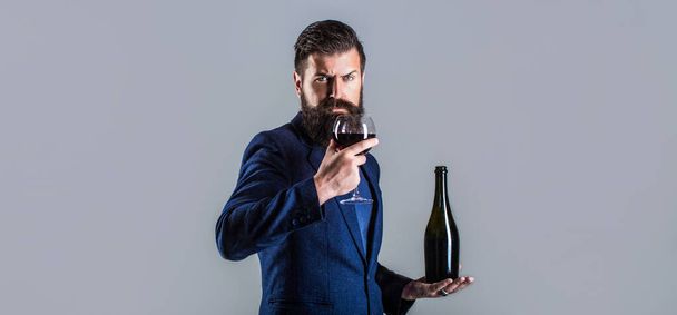 Red wine in bottle, wine glass. Sommelier man, degustator, winery. Man holding bottle with champagne, wine. Bottle, red wine glass. Beard man, bearded, sommelier, tasting - Photo, Image