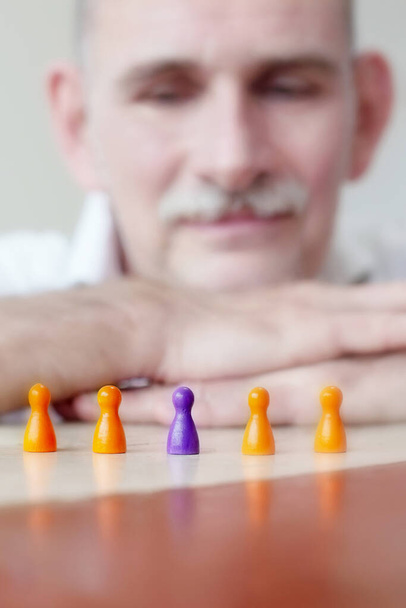 close-up of game pieces on table and businessman in his 50s - Zdjęcie, obraz