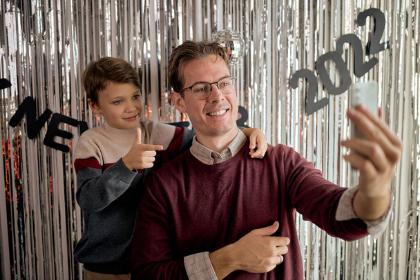 dad and son make selfie. concept of New Years and wish and dream Christmas family - 写真・画像