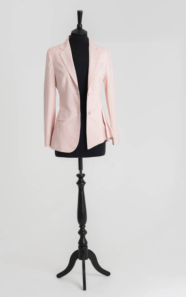 Англия, Великобритания. 2021 год. Женский розовый пиджак висит на кукле портного - Фото, изображение