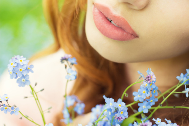 Big sexy lips girls with blue flowers in her hands - Photo, image