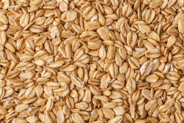 Rolled oat, oat flakes background or texture. Close up, directly above.Heap of dry rolled oats isolated. - Фото, зображення