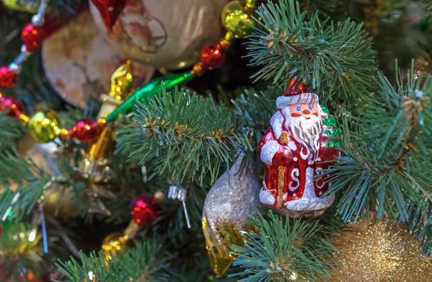 Brinquedo de Natal Papai Noel em um casaco vermelho com uma cana e uma árvore de Natal. - Foto, Imagem
