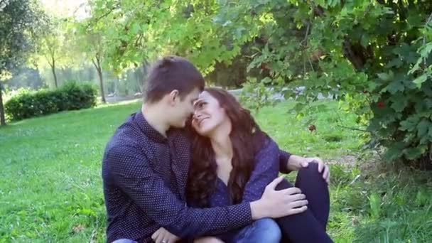 férfi és nő együtt ül a fűben, a parkban - Felvétel, videó